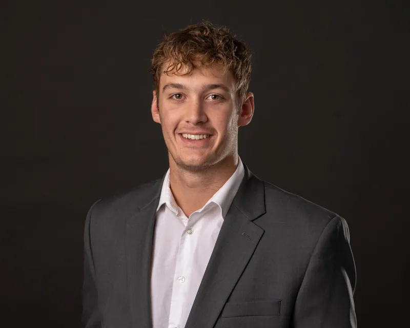 Gavin Filmer, Chief Executive Officer of Exceed the Odds, smiling in a gray blazer