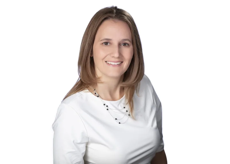 Laura Rich, Chief Operating Officer of Exceed the Odds, smiling in a white top